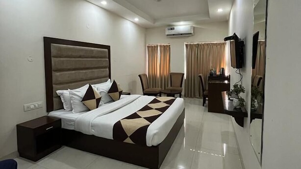 A modern hotel room with a large bed, a desk, and a TV. - HOTEL PARK ROYAL  (Panchkula)