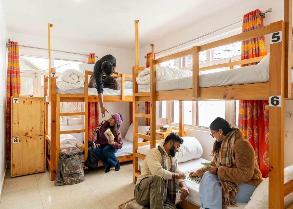 Un dormitorio con literas, numeradas del 5 al 8, y un pequeño armario de madera.