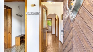 Un pasillo con puertas de madera, un perchero y un cartel que dice 'WELCOME'.