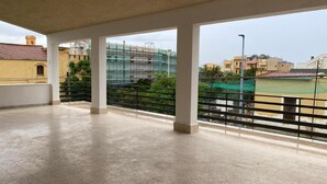 An open balcony with a view of a construction site and surrounding buildings.