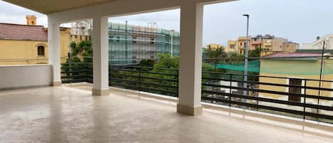 An open balcony with a view of a construction site and surrounding buildings.