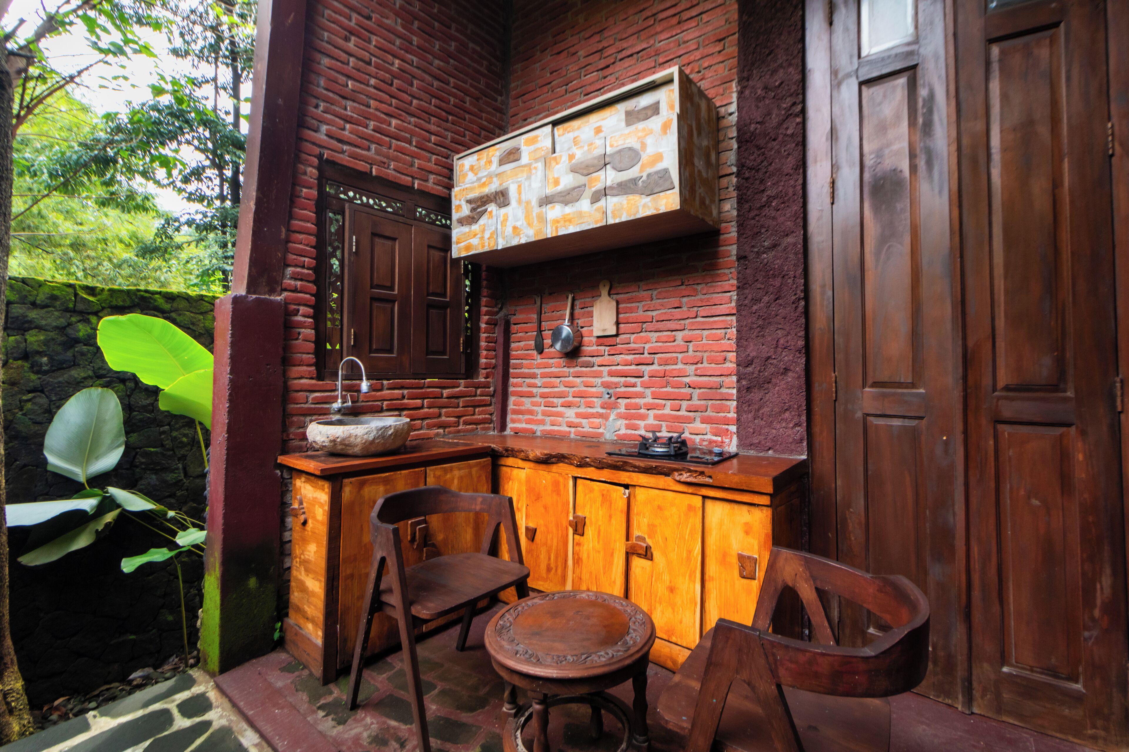 A rustic kitchen with a wooden counter, a sink, and a hanging pot rack.