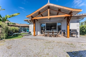 Une maison moderne dotée d’un patio couvert, d’un coin repas et d’un barbecue.