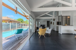 Un intérieur moderne avec une piscine, de grandes fenêtres et un espace cuisine.