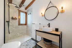 A modern bathroom with a shower, toilet, and sink.