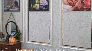 Une salle de spa avec des tableaux encadrés au mur, un miroir et une commode en bois où sont rangés les produits de toilette.