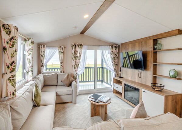 A living room with a sofa, a coffee table, a TV, and a wooden cabinet.