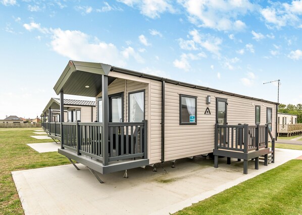 A mobile home with a porch, windows, and a door. - This stunning holiday home with a double bedroom and en suite W. (Hornsea)