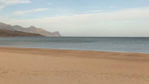 Una playa con una vista despejada de montañas al fondo.