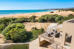 A balcony with outdoor furniture overlooking a beach and ocean. - Sea view and direct access to the sandy beach (Sampieri)