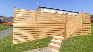 A wooden fence with a staircase leading up to a white building. - Glenside 12 Superior (Hastings)