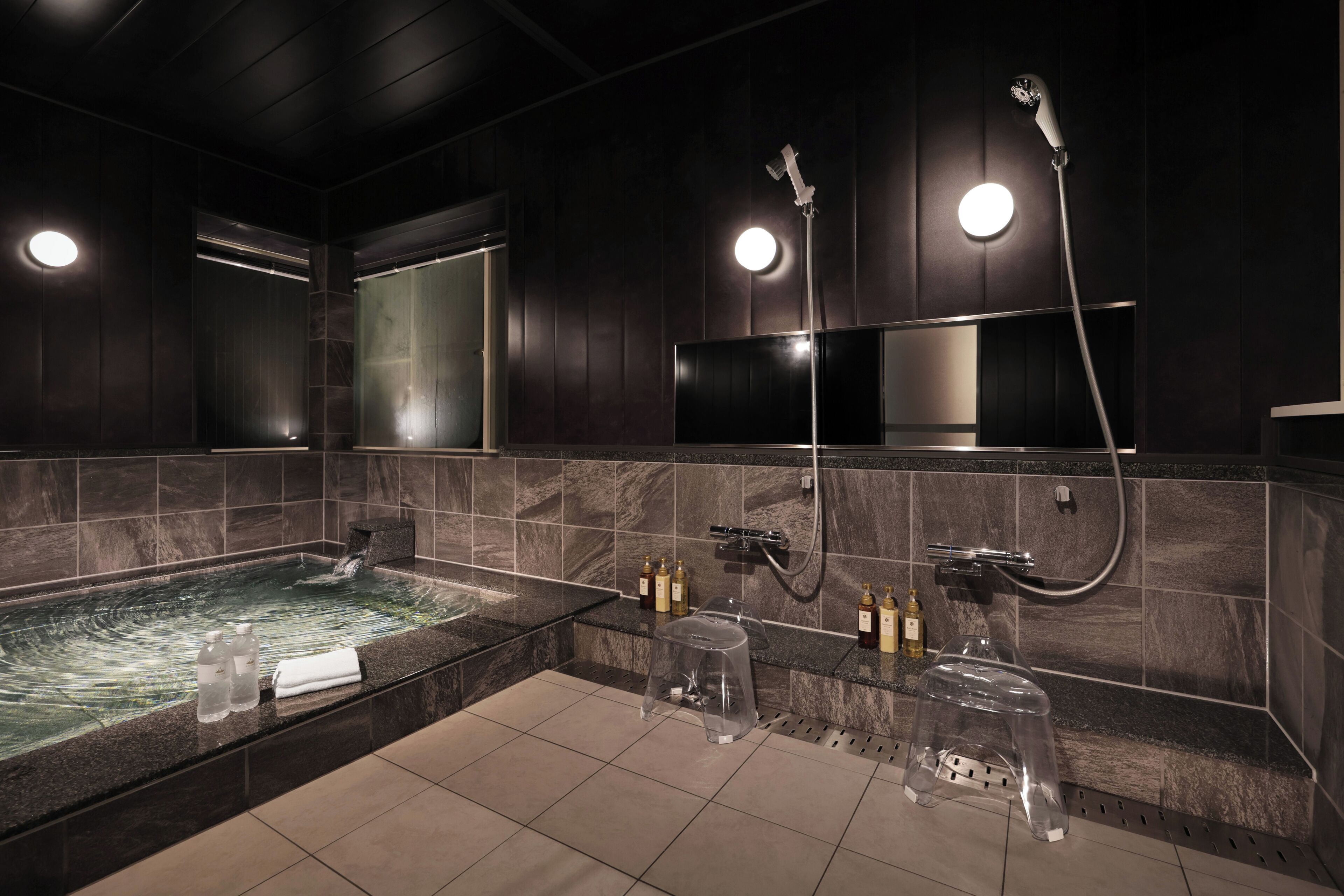 A modern bathroom with a large bathtub, a separate shower area, and a glass partition.