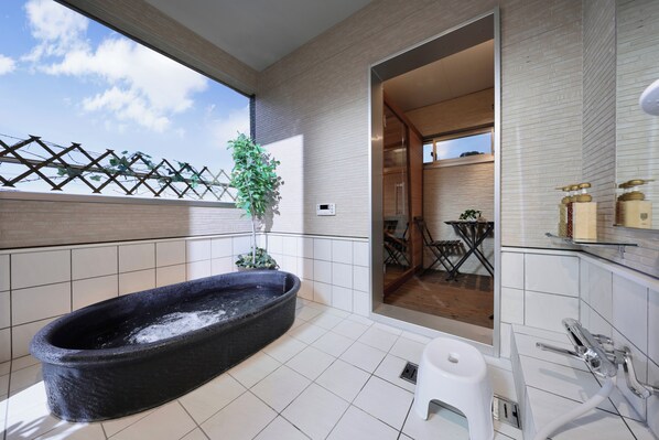 Une salle de bain moderne avec une baignoire sur pieds, des toilettes et un lavabo.