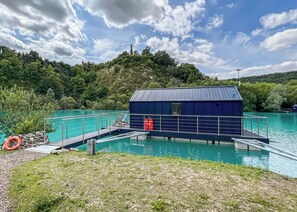 A swimming pool with a dock and a small building, surrounded by greenery and a clear sky. - 1 bedroom accommodation in Halling (Halling)