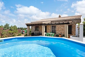 Una piscina con un edificio in pietra sullo sfondo.