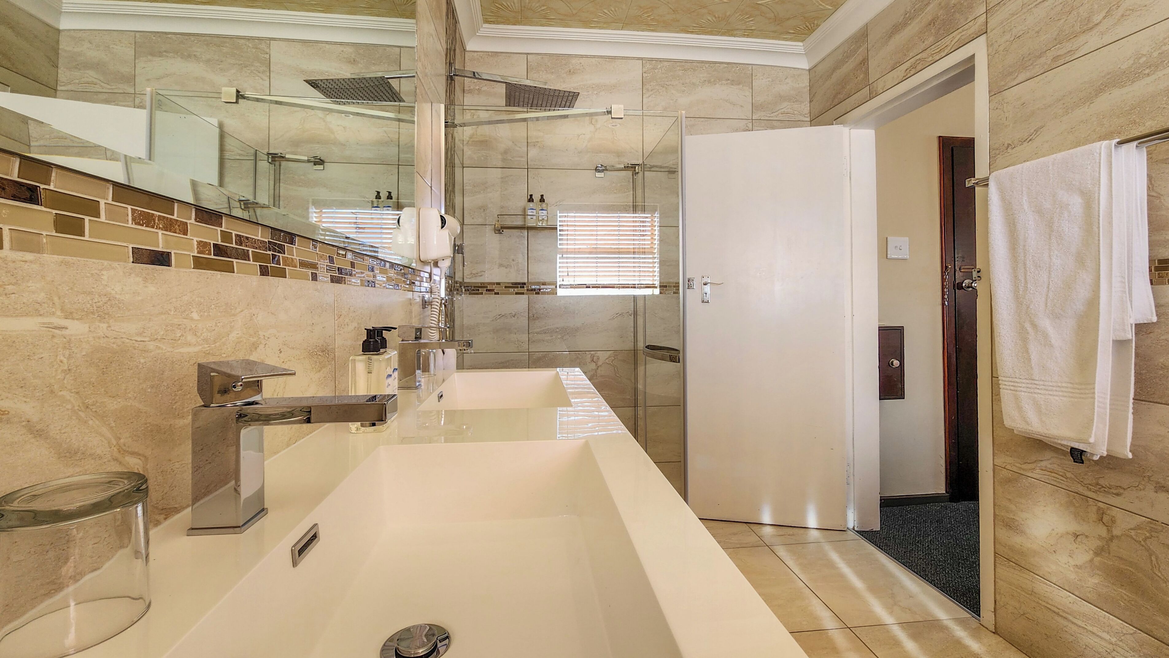 A modern bathroom with a large sink, a glass shower enclosure, and a walk-in shower.
