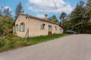 Un bâtiment à deux étages, doté d’un toit recouvert de tuiles, d’une cheminée et d’un petit porche à l’avant.