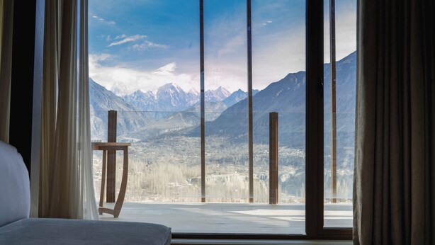 A room with a large window offering a mountain view. - Ambiance Resort Hunza (Karimabad)