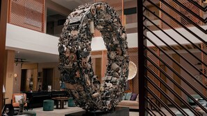 A large, intricate sculpture made of various mechanical parts in a modern lobby with a staircase and seating area. - Ambiance Resort Hunza (Karimabad)