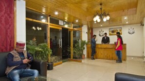 A reception area with a wooden ceiling, glass doors, and a reception desk.