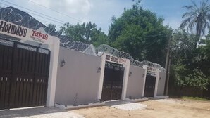 Una propiedad cerrada con un cartel que dice "Sonko Holidays" y "Tapis".