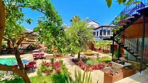 Un pati amb una piscina, mobiliari exterior i diferents plantes.