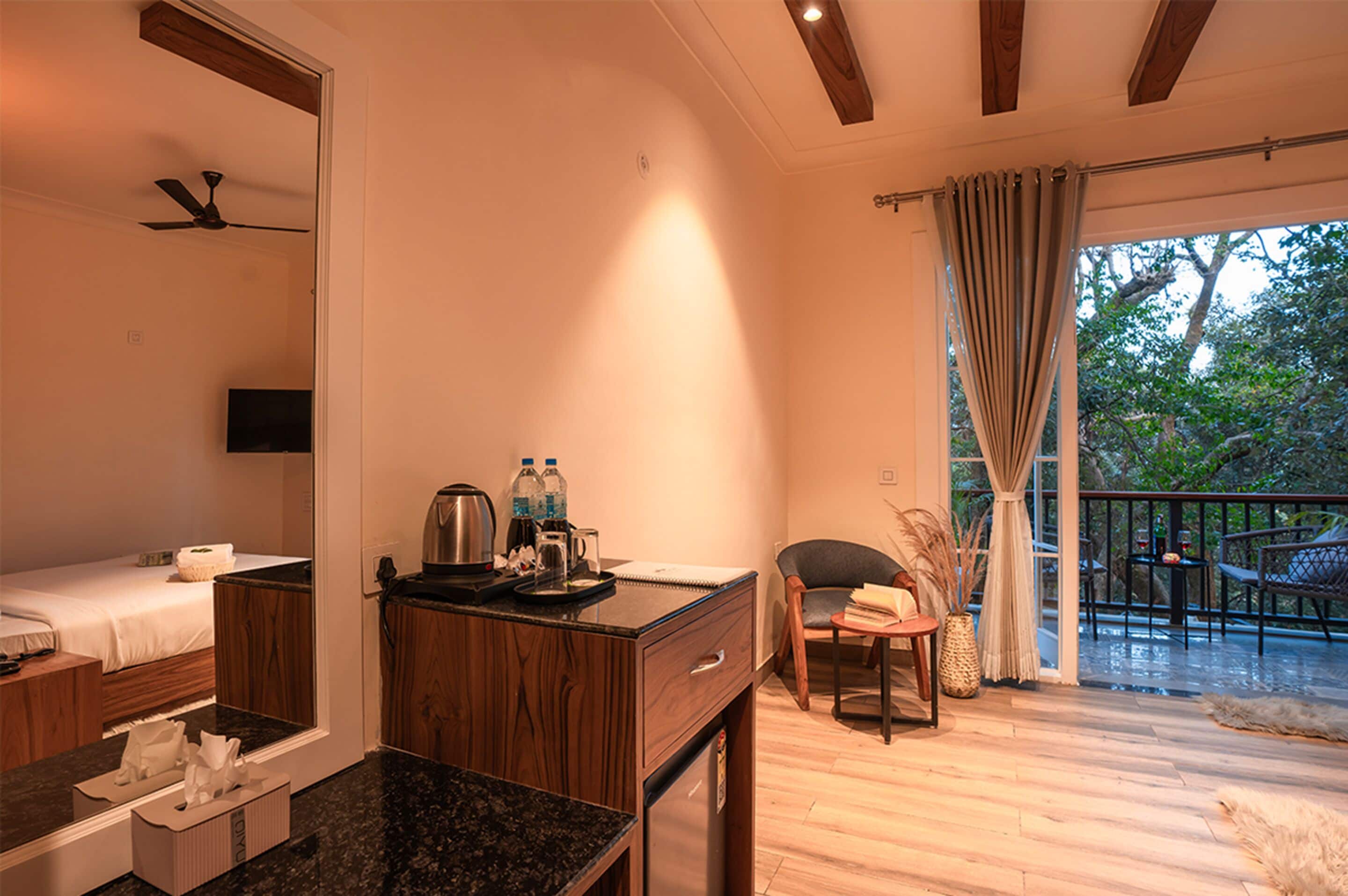 Ein Hotelzimmer mit Bett, Schreibtisch mit Spiegel, einer Kaffeemaschine und Blick ins Freie.