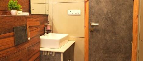A bathroom with a toilet, sink, mirror, and wooden wall paneling.
