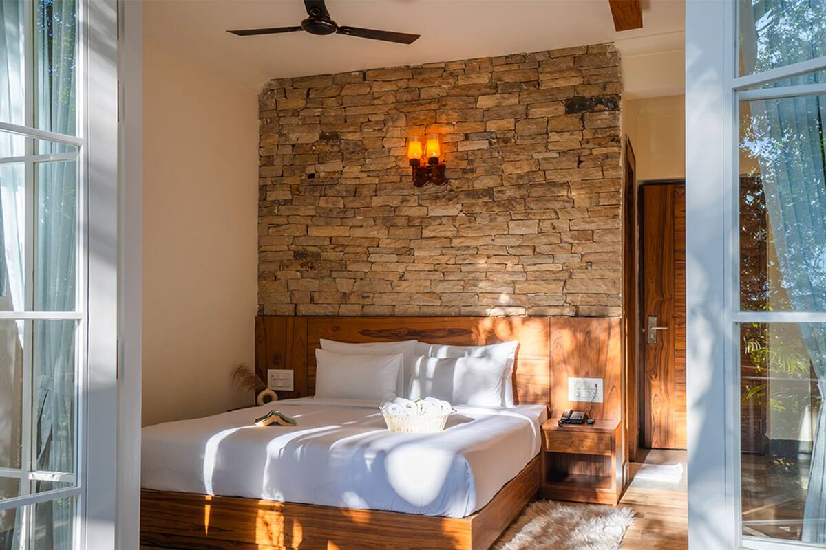 Ein Schlafzimmer mit Steinwand, Holz-Kopfteil und einem großen Bett.