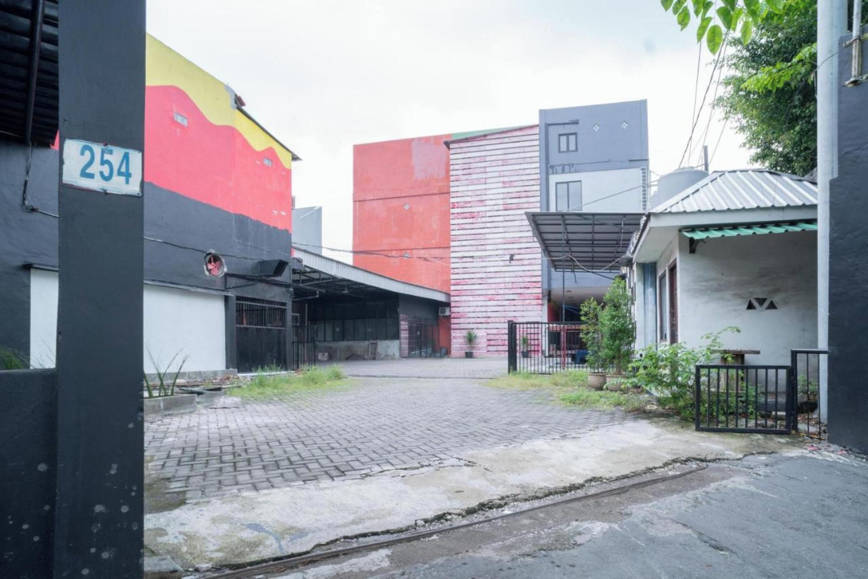 A building with a large mural, a number '254' sign, and a paved courtyard.