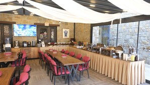 Un restaurante con una barra larga, varias mesas y sillas.