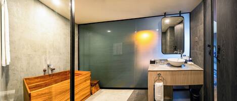 A modern bathroom with a wooden vanity, a large mirror, and a glass shower enclosure.