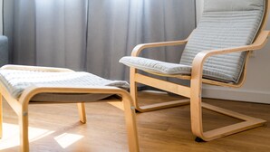 Une chaise en bois dotée d’un siège et d’un dossier rembourrés, placée sur un plancher en bois.