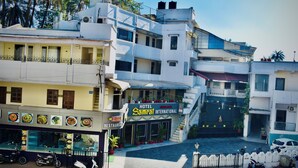 A hotel with a signboard for 'Samrat International' and a restaurant named 'Hollywood Boulevard'.