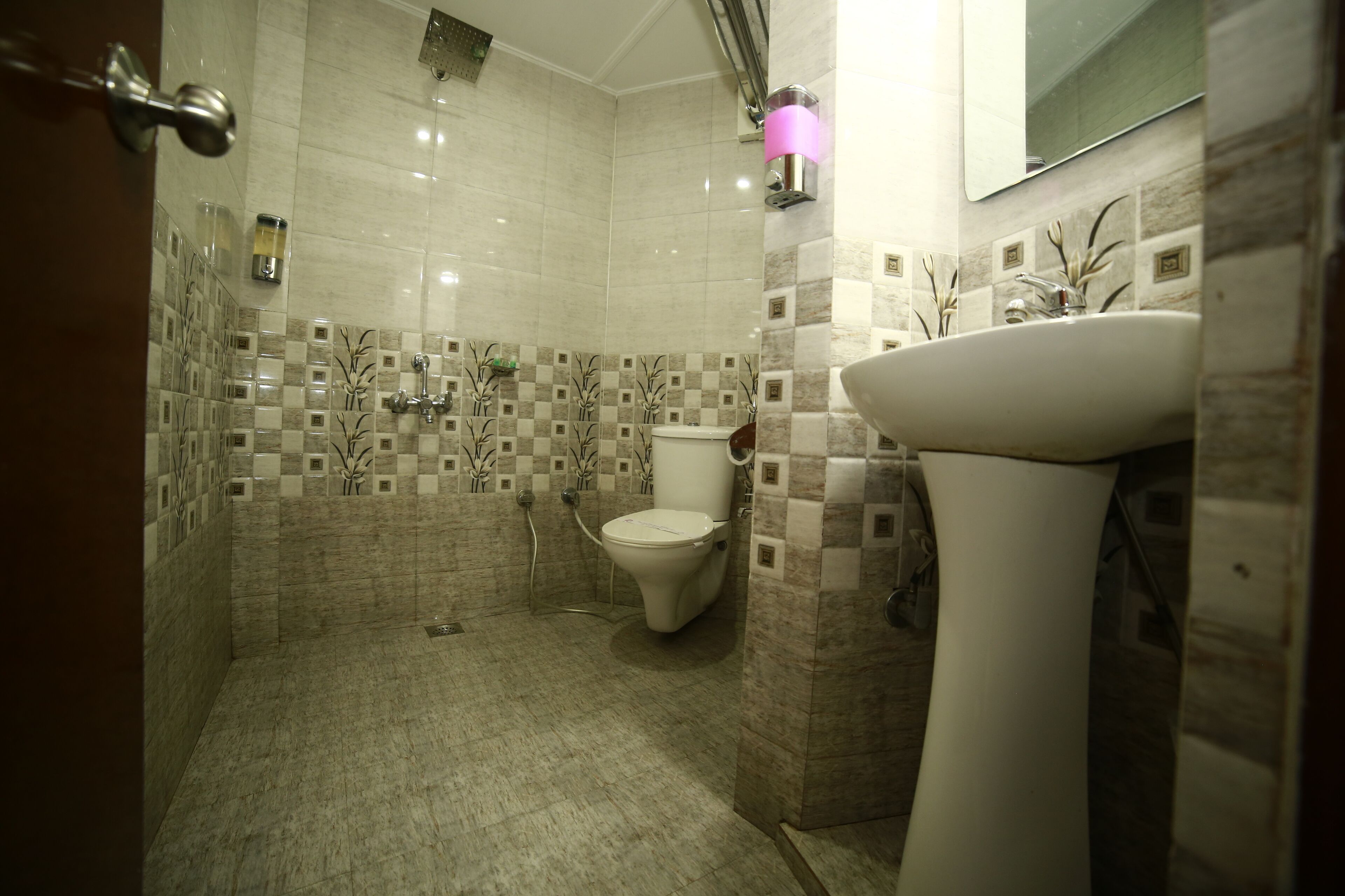 A bathroom with a toilet, sink, and shower area.