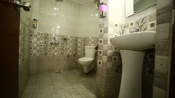 A bathroom with a toilet, sink, and shower area.