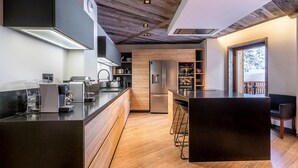 A modern kitchen with a central island, wooden flooring, and built-in appliances. - Luxurious 7-room apartment for 14 pers. in Avoriaz with wellness access (Avoriaz)