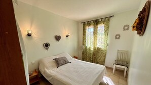 Ein Schlafzimmer mit Bett, Stuhl und dekorativer Wandbeleuchtung.