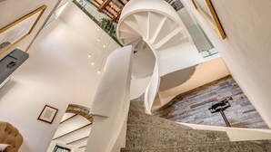 A spiral staircase with a stone floor, white walls, and a wooden ceiling. - Villa Benedetta - Homelike Villas (Osimo)