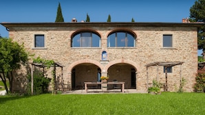Un edificio de piedra con dos arcos y una mesa al frente.