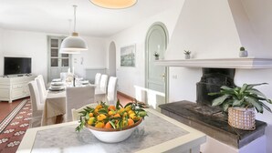 Een moderne woonkamer met een eethoek, een open haard en een televisie.