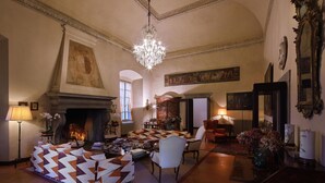 Un salon spacieux doté d’une cheminée, de sièges confortables et d’un lustre.