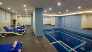 A swimming pool area with lounge chairs and a blue-tiled pool. - Enala AlKhobar Hotel (Al Khobar)