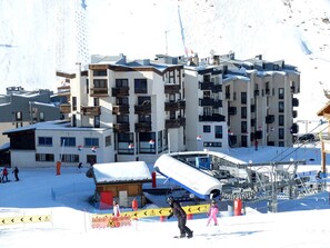 A ski resort with multiple buildings, including a hotel with balconies and a ski lift area. - Comfortable studio with balcony, ski-in/ski-out (Tignes)