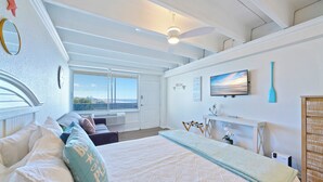 A bedroom with a large bed, a ceiling fan, a TV, and a window with blinds. - FB Terrace Studio! Inquire for Monthly Rates (Panama City Beach)