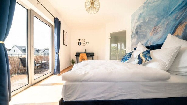 A bedroom with a large bed, a desk, and a view of the outside. - Penthouse-Suite near University (Gießen)