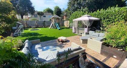 Central Elegance: Chic Family Abode with Lush Garden for kids, BBQ, and Hot Tub