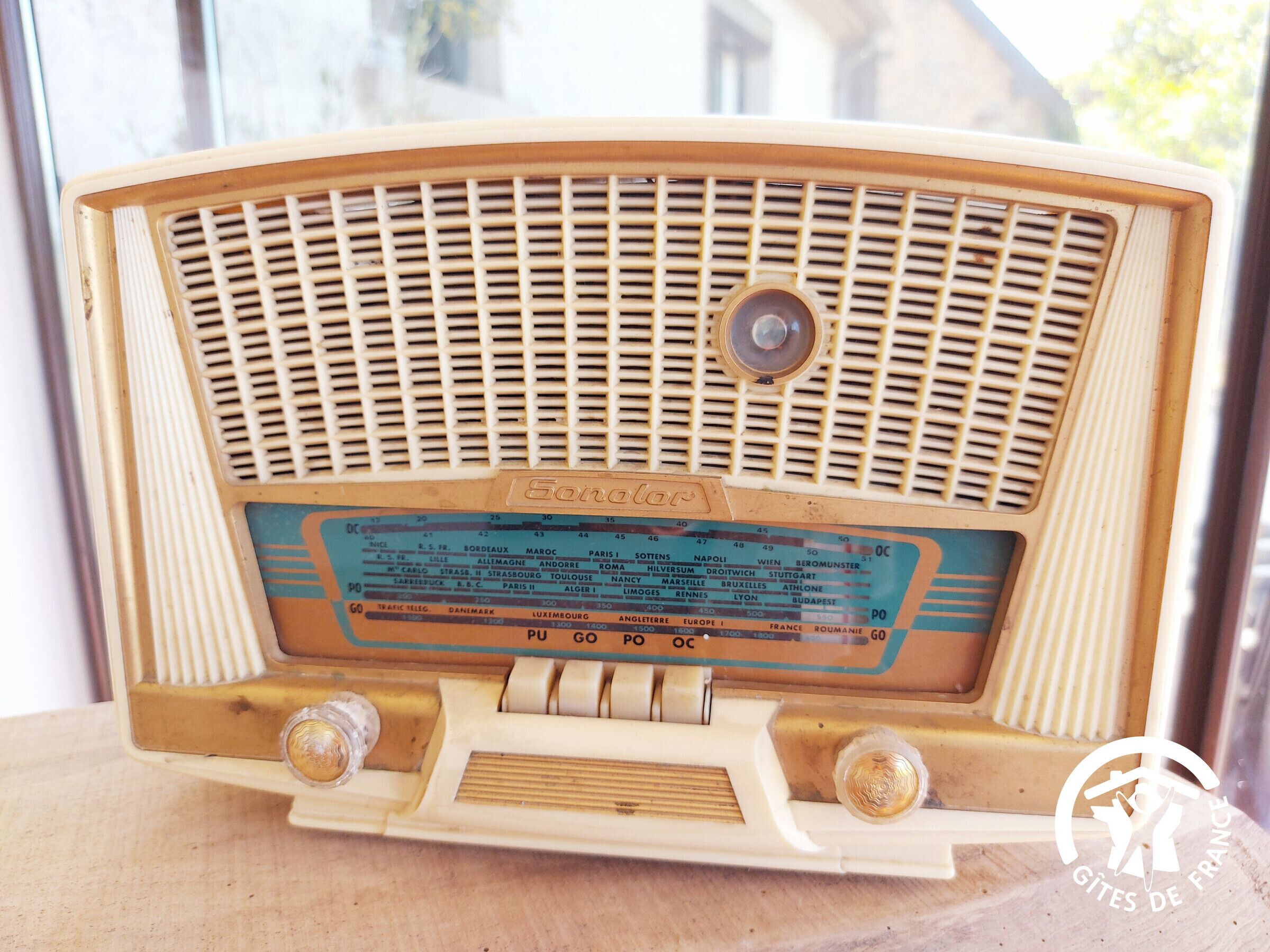 A vintage radio with a frequency tuning dial and a brand name visible.
