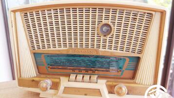 A vintage radio with a frequency tuning dial and a brand name visible.