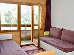 Una stanza con un letto, un divano e una porta scorrevole in vetro che dà su un'area esterna.